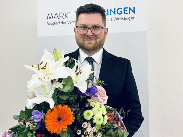Bürgermeister Thomas Reicherzer hält einen großen Blumenstrauß in der Hand.