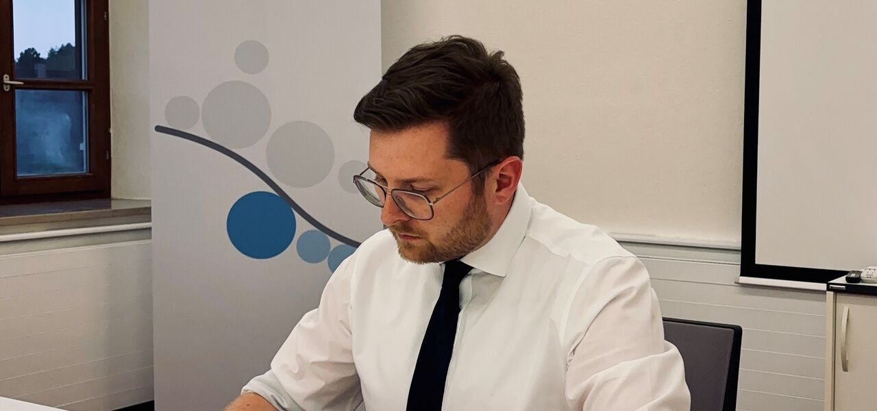 Thomas Reicherzer am Schreibtisch mit Schreibgerät in der Hand