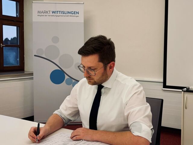 Thomas Reicherzer am Schreibtisch mit Schreibgerät in der Hand